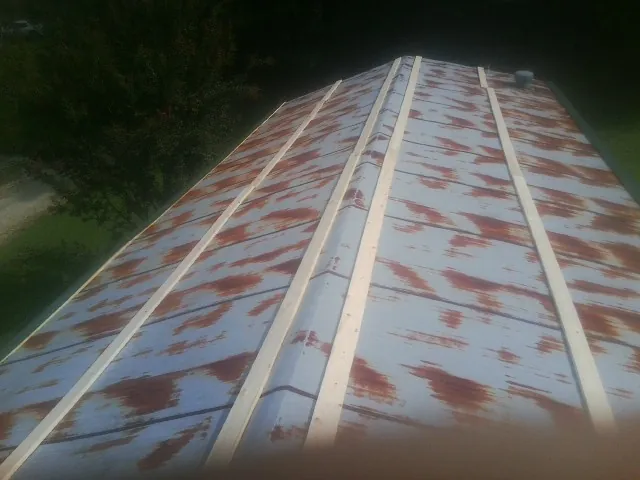 Rusted metal roof panels with new wood purlins before replacement — Storm Damage Roof Repair in Blue Point by Roofing Brothers