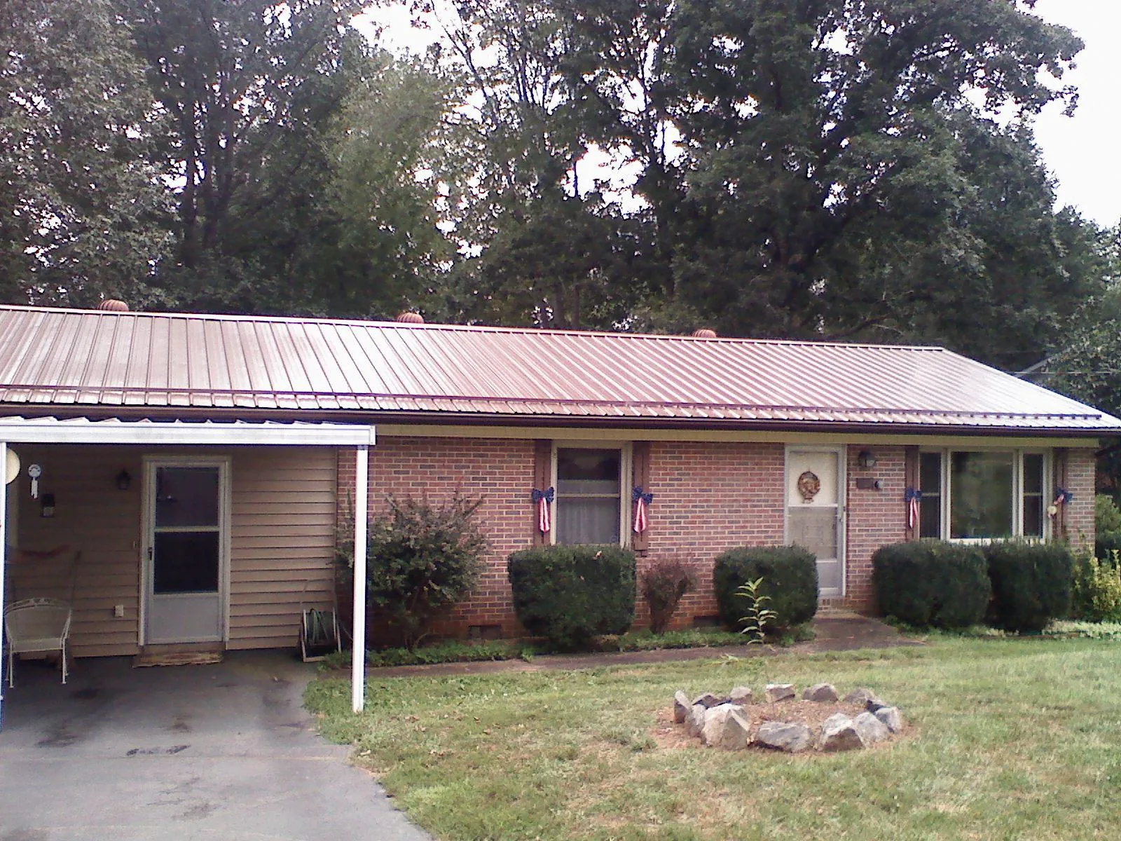 Bronze metal roof and carport on a brick ranch home — Roof Repair work by our crew in Blue Point